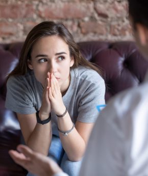 Young woman visiting therapist counselor. Girl feeling depressed, unhappy and hopeless, needs assistance. Serious disease, unwilling pregnancy, abort or death of loved one, addiction to drugs concept